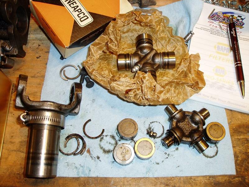 U-joint and yolk disassembled. The new one is on the paper. The hose clamp on the yolk is to remind me of which side of the driv