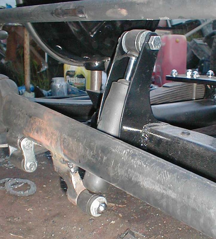 The new shock mounts, shocks, and revised bottom mounts on the radius rod. Concrete stake helped fill the gap between the actual