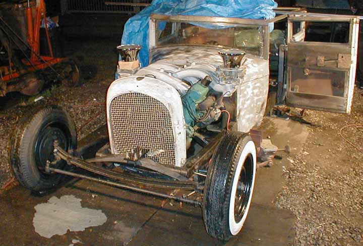 Getting down to the wire and the weather is NOT cooperating. Work continues nonetheless. Grille is set in place and carburetors 