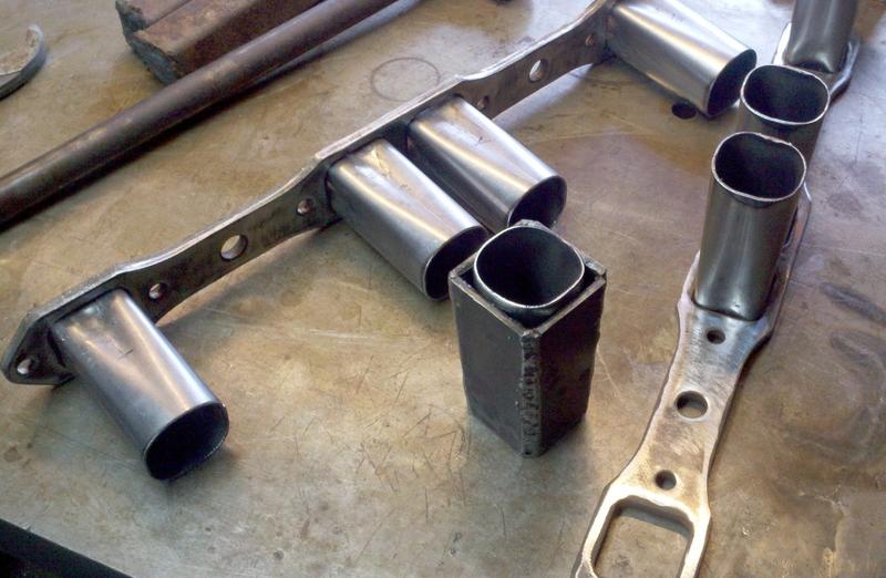 New Exhaust! Flanges bought. 2" Tubes cut. Taper form made to transition round into square. Big press to form tubes. Round 
