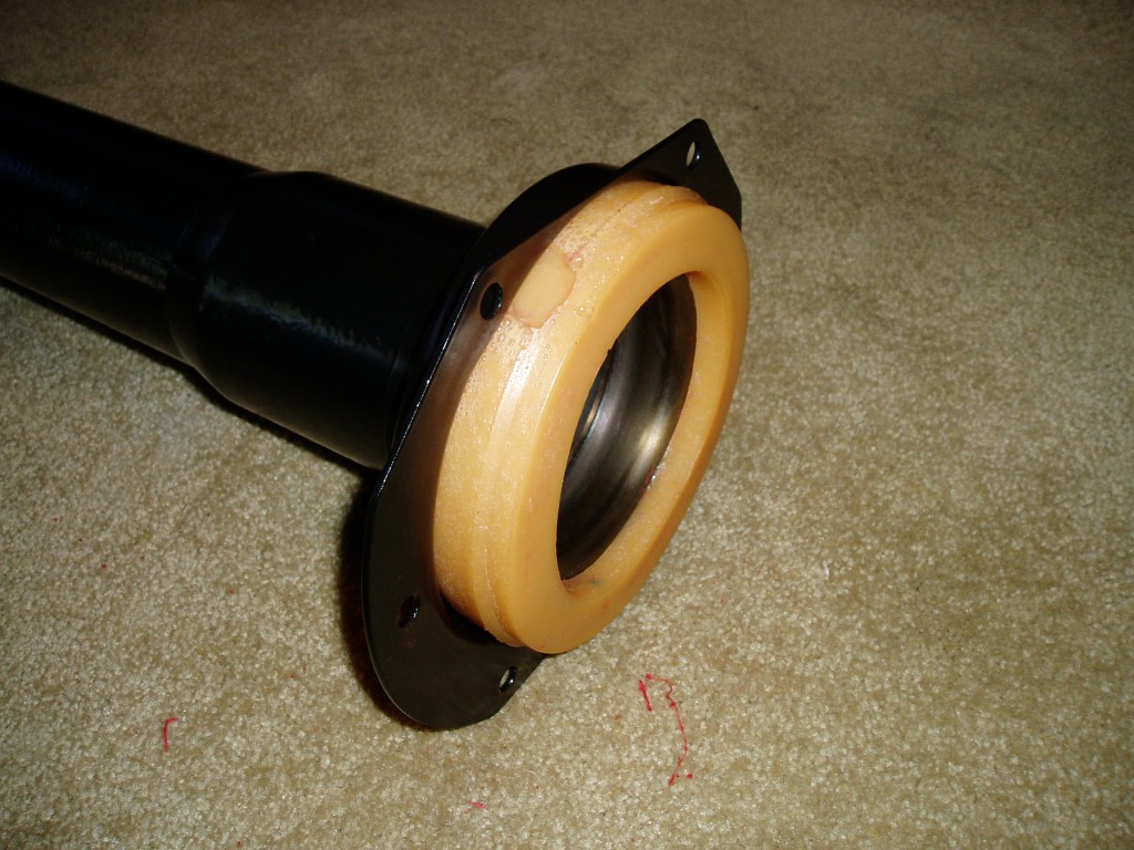 Torque Tube Trunion (rubber donut) mounted. This bolts to the transmission, the driveshaft with u-joint goes inside the tube. 